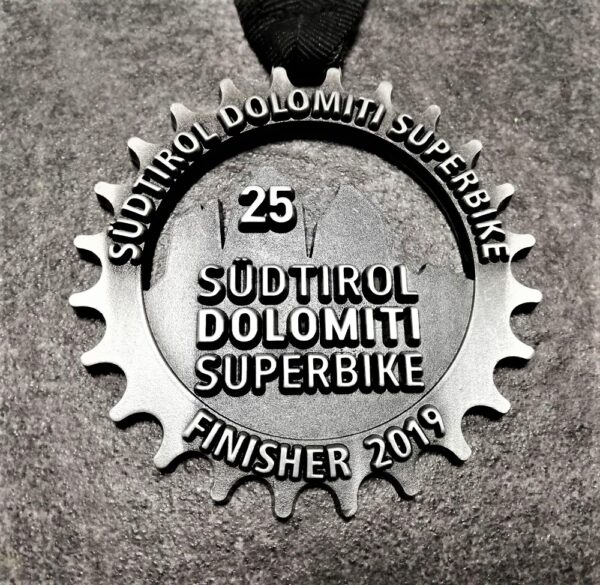 customised Dolomiti Superbike 2019 medal in embossed 2D perforated metal with antique silver finish and personalised silkscreen printed ribbon