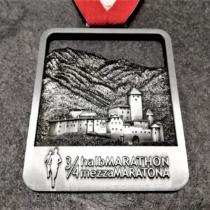 3-quarter metal embossed 3D antique silver finish brunico half marathon medal with red and white ribbon