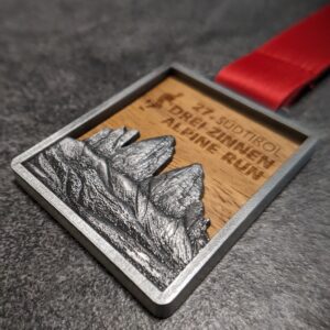 medaglia personalizzata drei zinnen alpine run in legno e metallo a rilievo 3D finitura argento antico con nastro personalizzato in sublimazione vista laterale