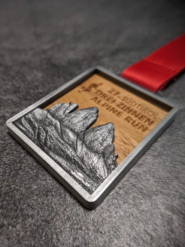 medaglia personalizzata drei zinnen alpine run in legno e metallo a rilievo 3D finitura argento antico con nastro personalizzato in sublimazione vista laterale