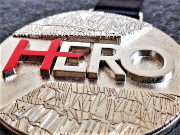 customised hero medal in 3D embossed metal with a shiny silver finish with silkscreen printing and sublimation personalised ribbon