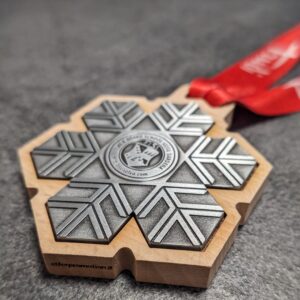medaglia personalizzata skischool selva in legno naturale fsc con inserto in metallo a rilievo 2D finitura argento antico con nastro personalizzato in sublimazione vista laterale
