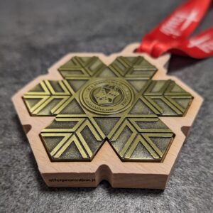 medaglia personalizzata skischool selva in legno naturale fsc con inserto in metallo a rilievo 2D finitura bronzo antico con nastro personalizzato in sublimazione vista laterale