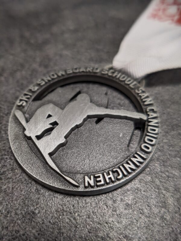 custom san candido snowboarding skischool medal embossed metal 2D multi-layered no enamel antique silver finish with personalized sublimation ribbon side view