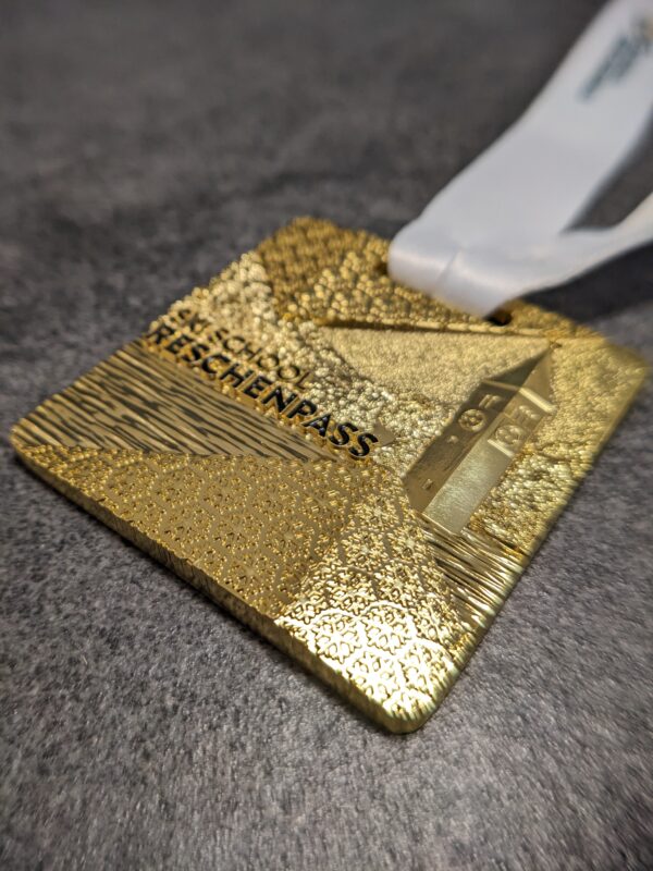 custom skischool reschenpass medal 3D gold finish embossed metal with personalized sublimation ribbon side view