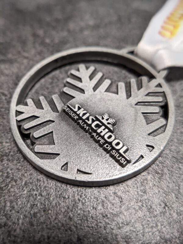 custom skischool seiser alm alpe di siusi medal in 2D metal embossing without enamel antique silver finish with personalized sublimation ribbon side view