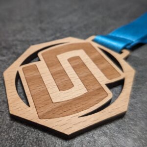 custom stelvio marathon octagonal medal in natural laser-cut and engraved wood with personalized sublimation ribbon side view