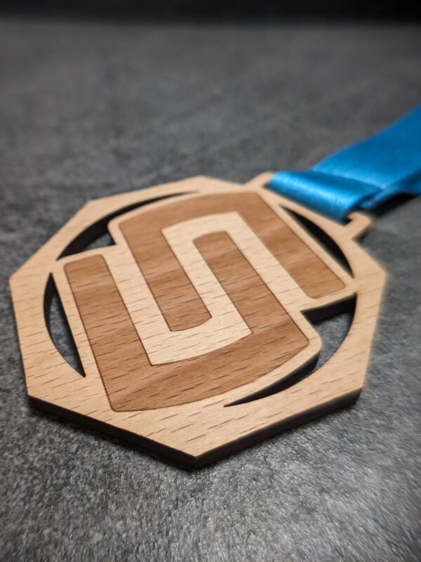 custom stelvio marathon octagonal medal in natural laser-cut and engraved wood with personalized sublimation ribbon side view