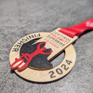 custom südtirol dolomiti superbike medal made of natural wood laser cut and uv printed with stacked layers with personalized sublimation ribbon side view